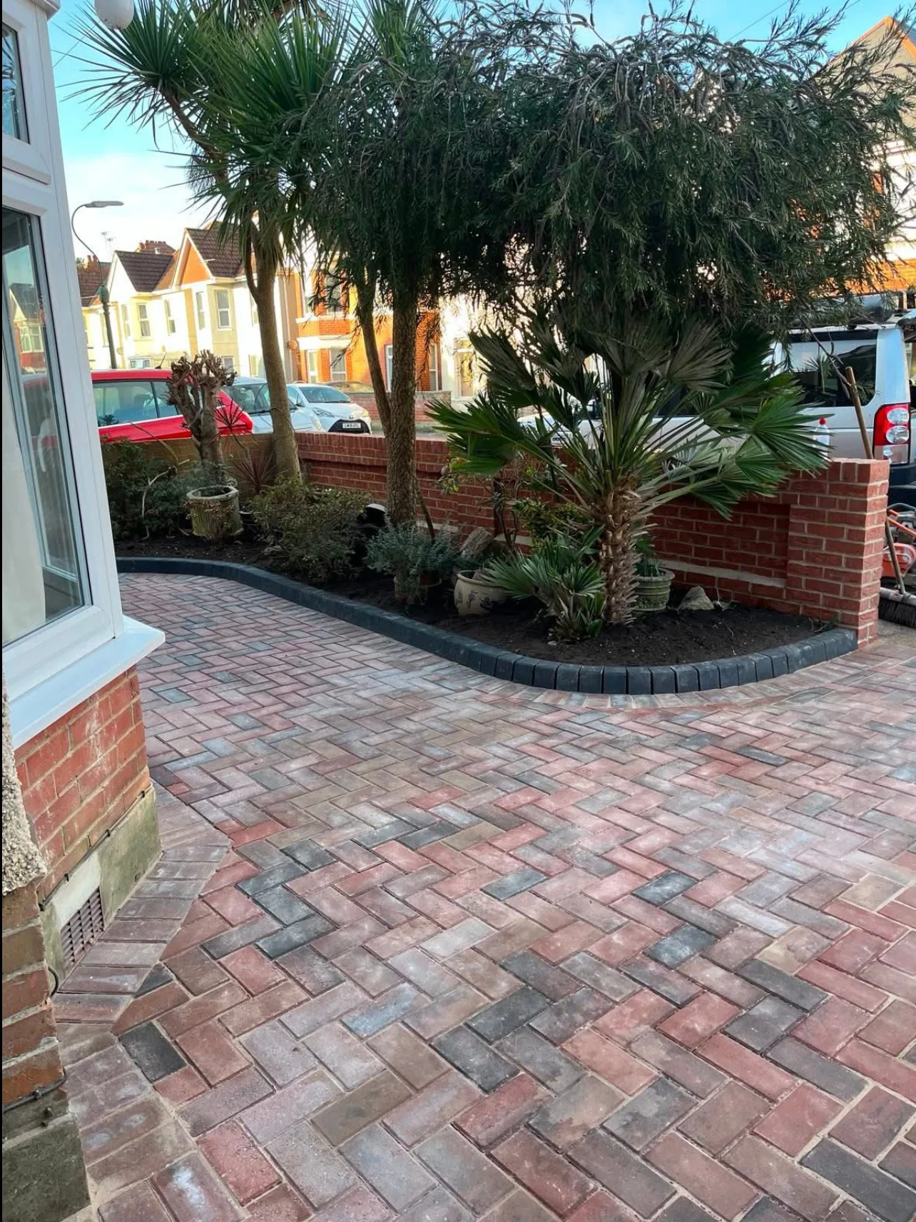 Block-paved driveway laid in herringbone with a kerbed edge, a new brick garden wall and planted border at a property in Charminster, built by KML Construct